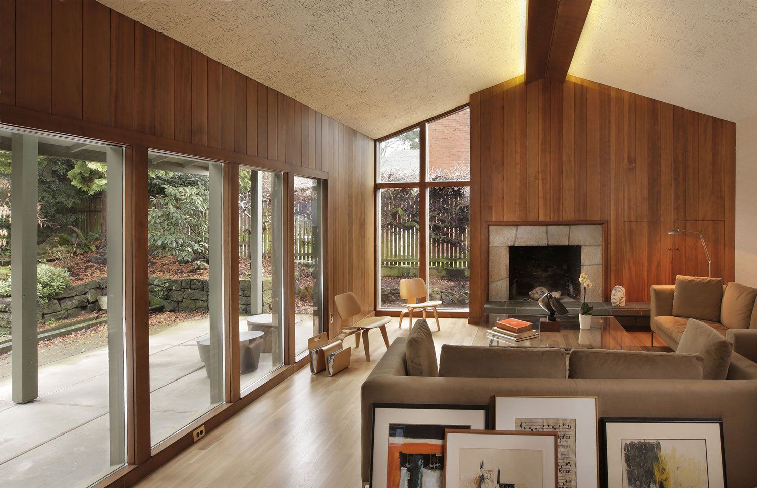From the dining room, the view of the living room fireplace with window wall to the back on the left.