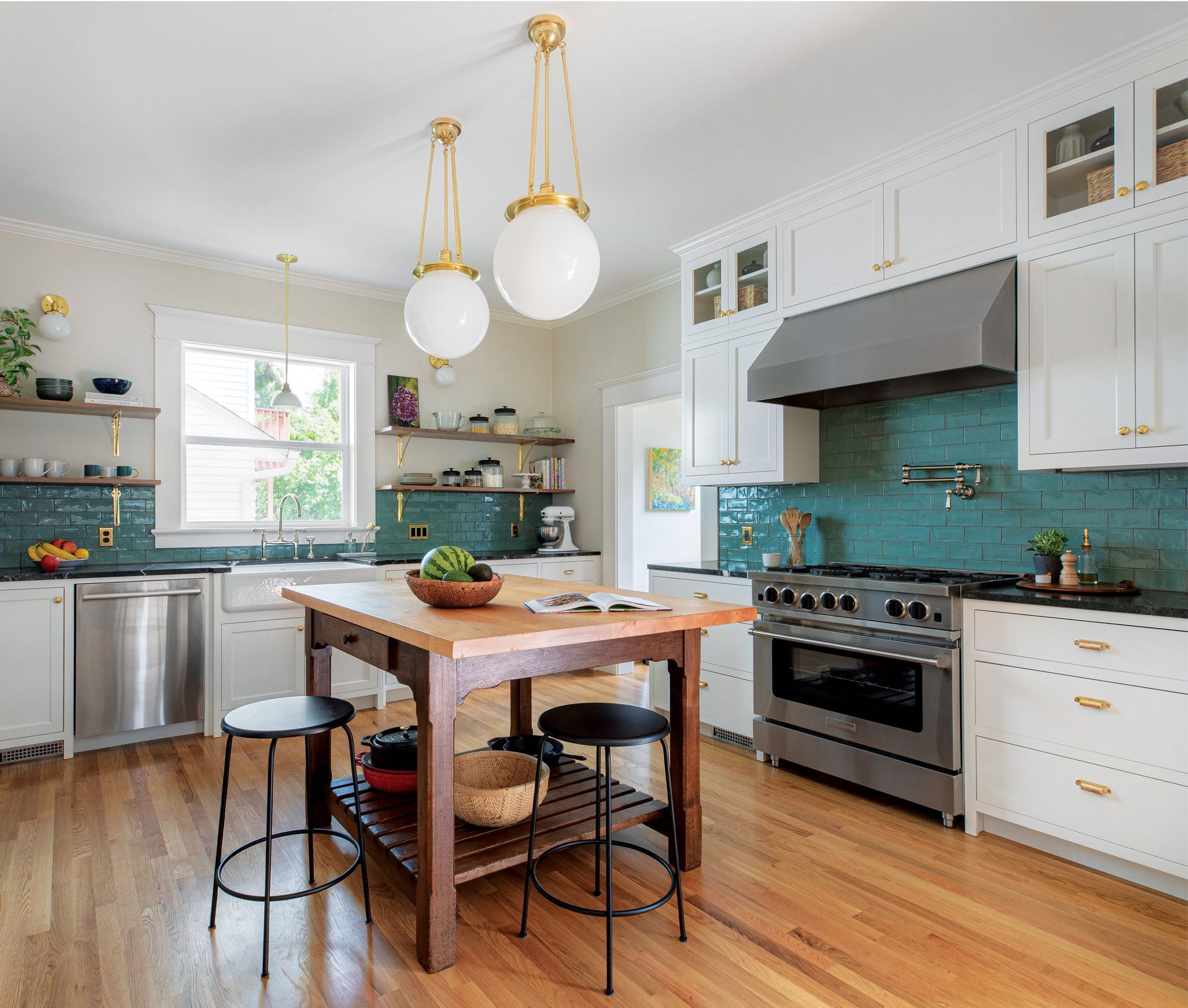 A kitchen with white cabinets , stainless steel appliances , and a wooden island.