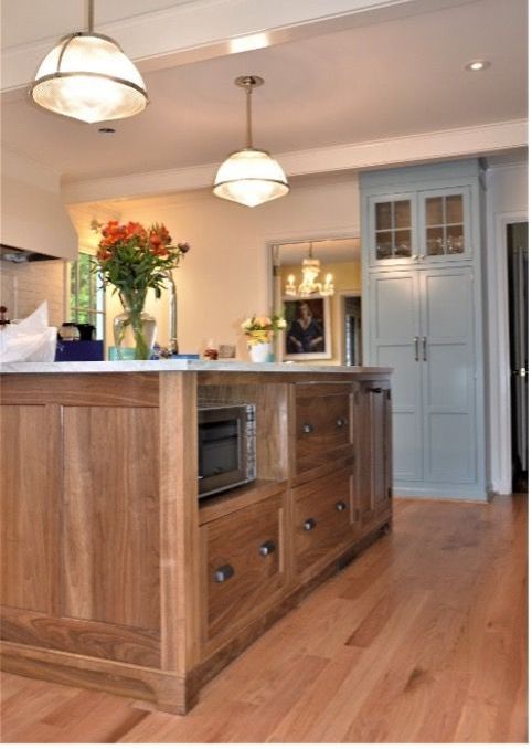 A kitchen with a large wooden island in the middle