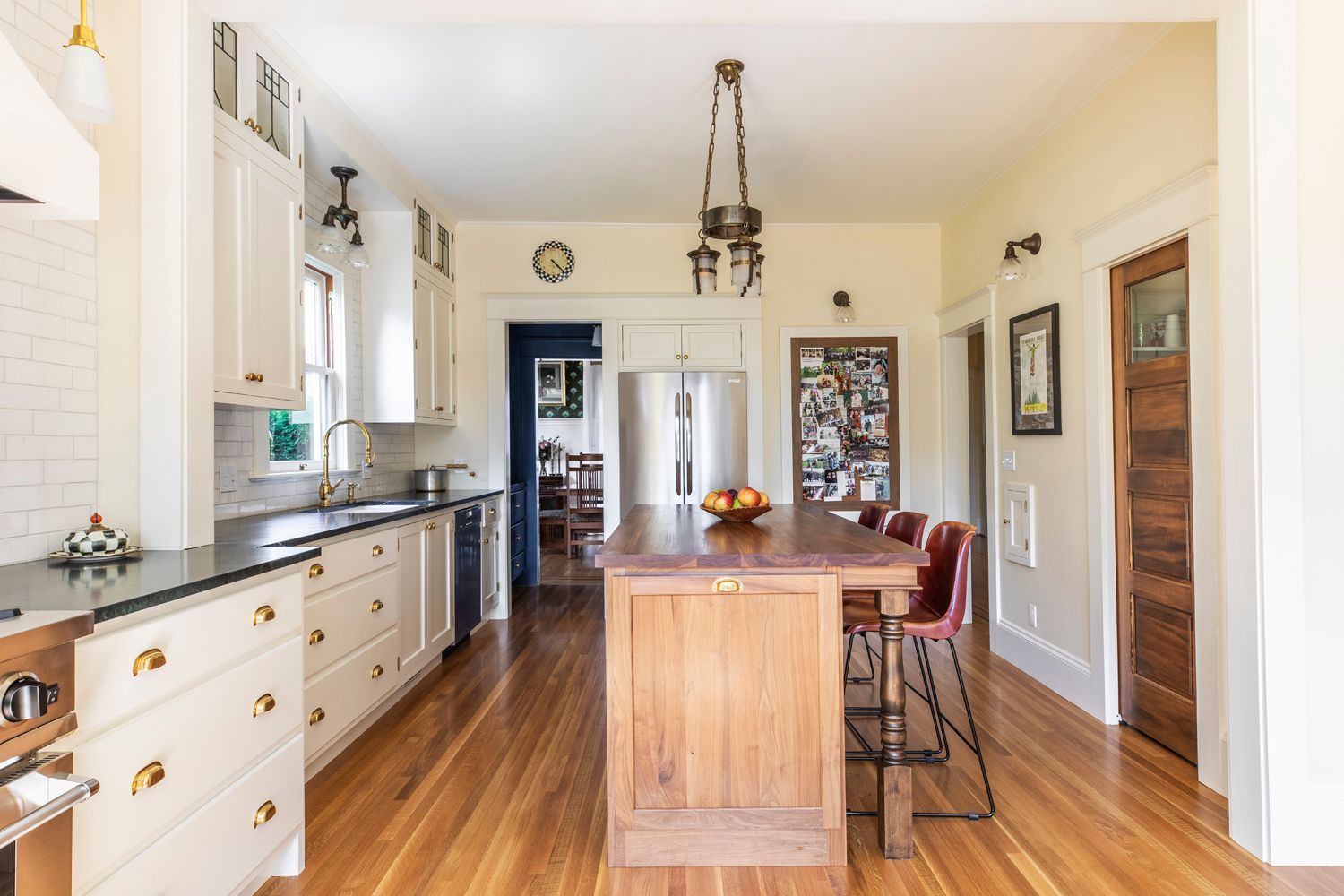 View of the kitchen from the back of the house, with stain grade island and white perimeter cabinets