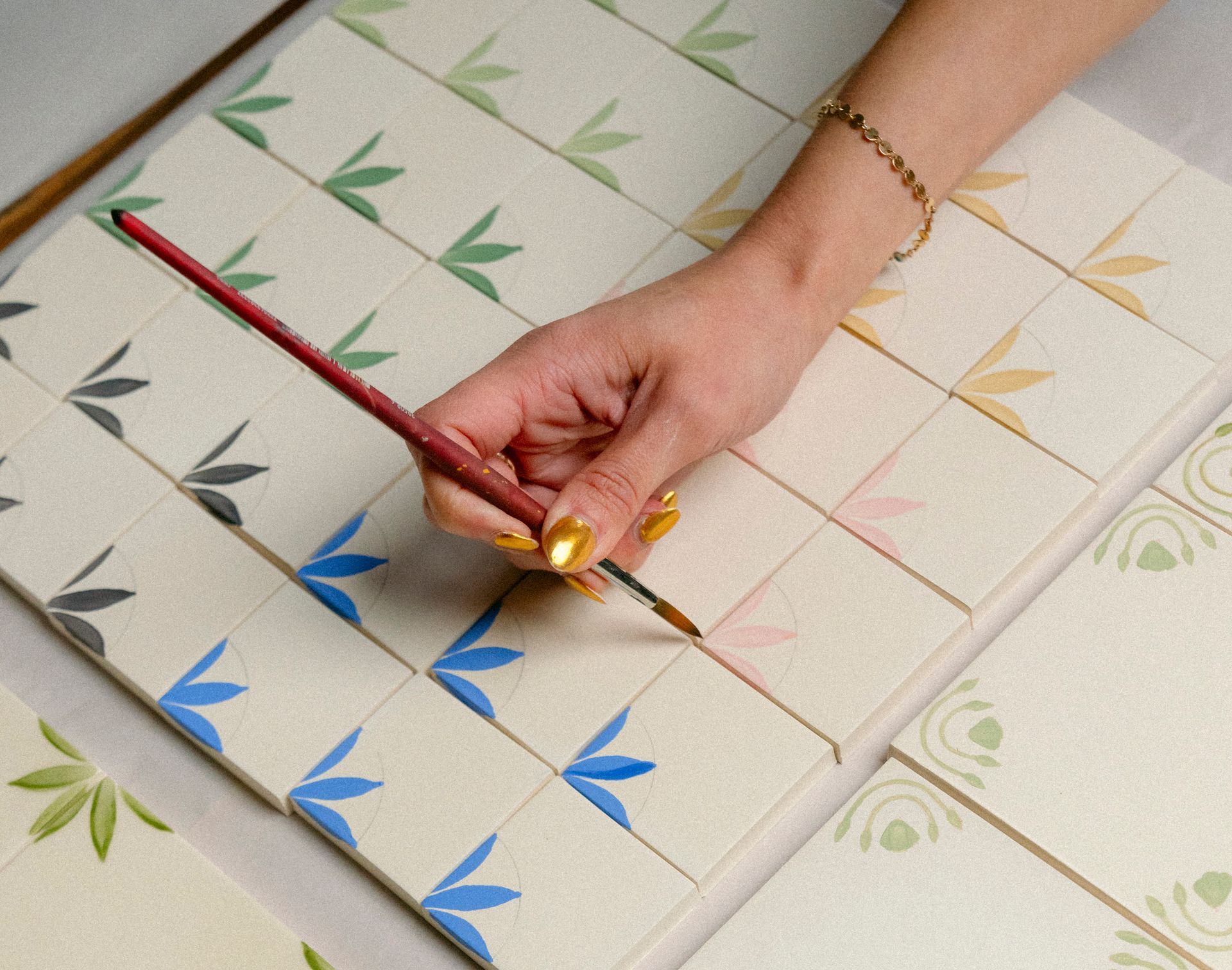 One of Lonesome Pictopia's artisans hand-paints individual ceramic tiles.