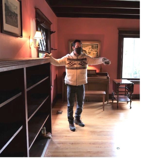 A man wearing a mask is standing in a room