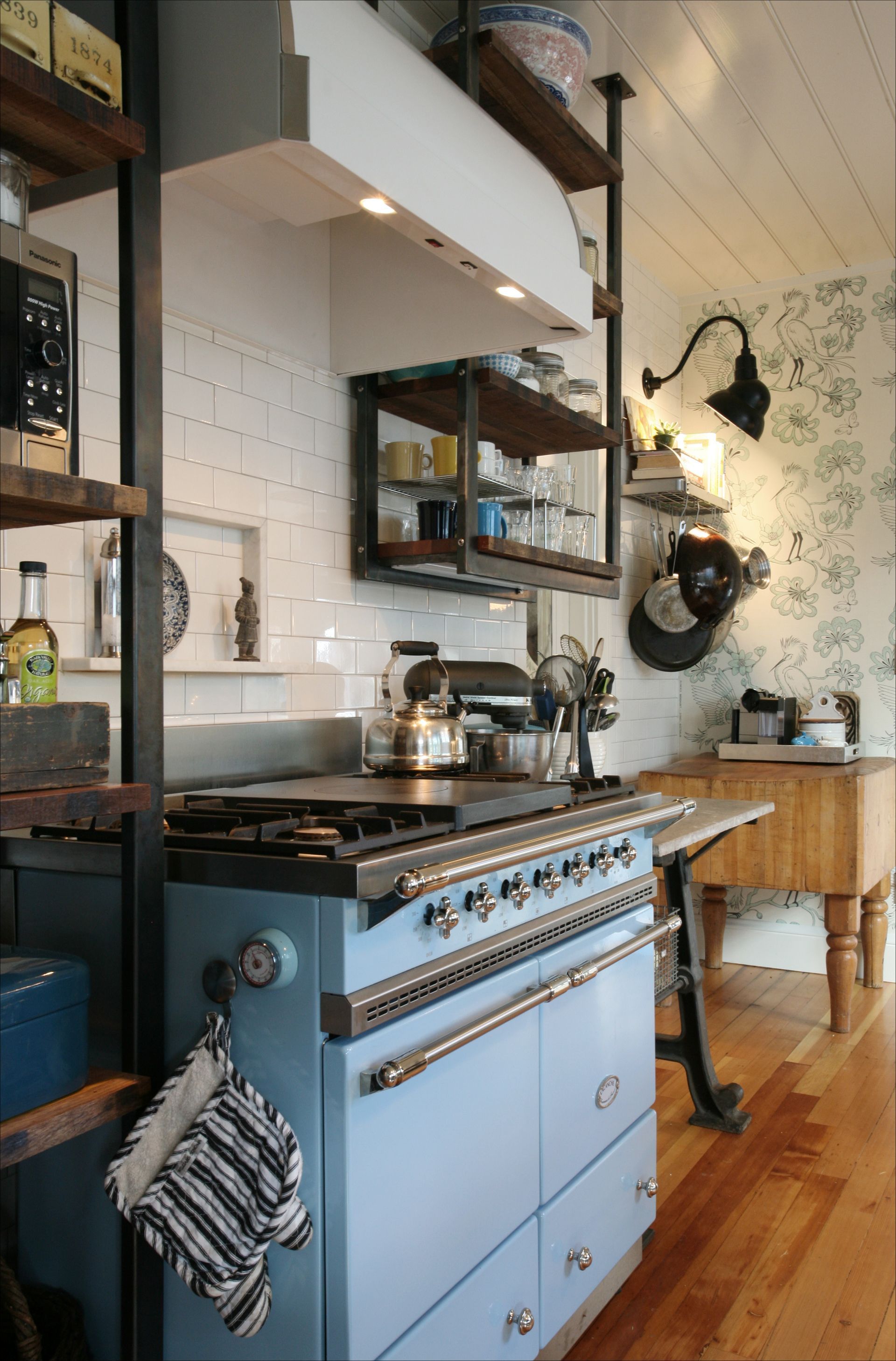 A kitchen with a blue stove and a wooden table