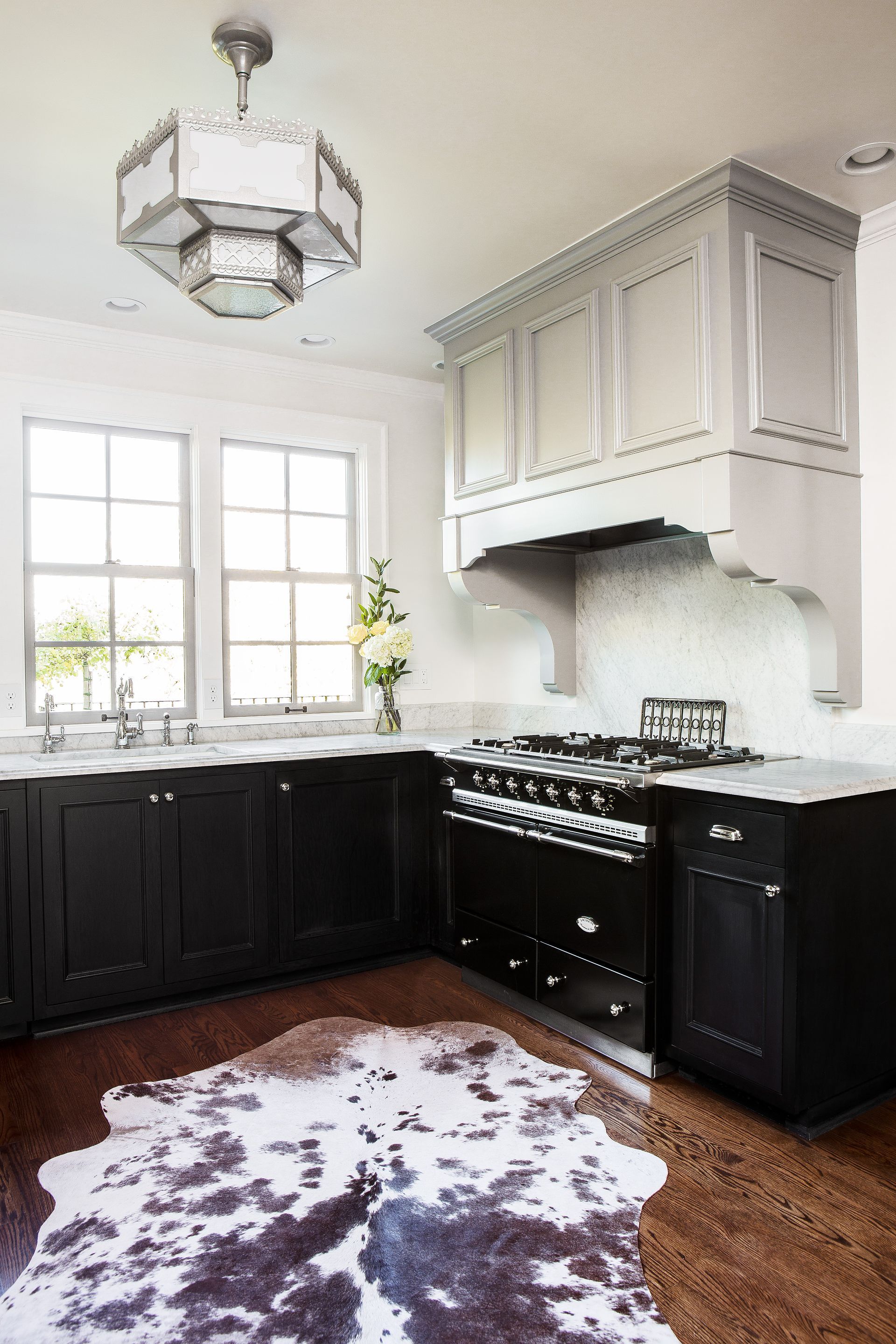 Looking at the kitchen corner between the sink wall and the Lacanche range wall, with an antique pendant above.