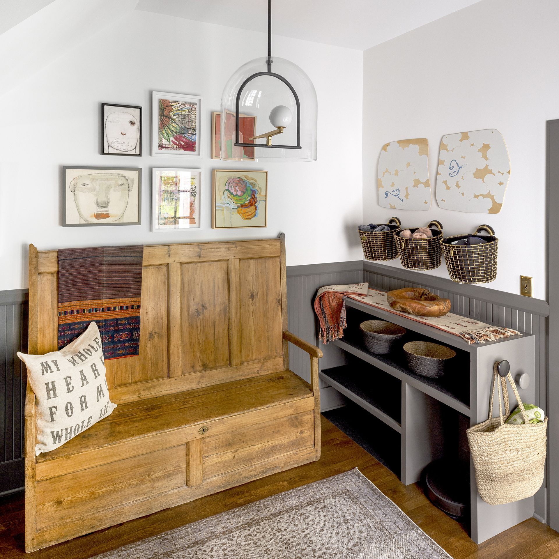 The side entry/mudroom of this large 1913 Colonial Revival home features a welcoming bench (with storage) and custom-sized cubbies for often-used items, incluiding the first floor robo-vac.