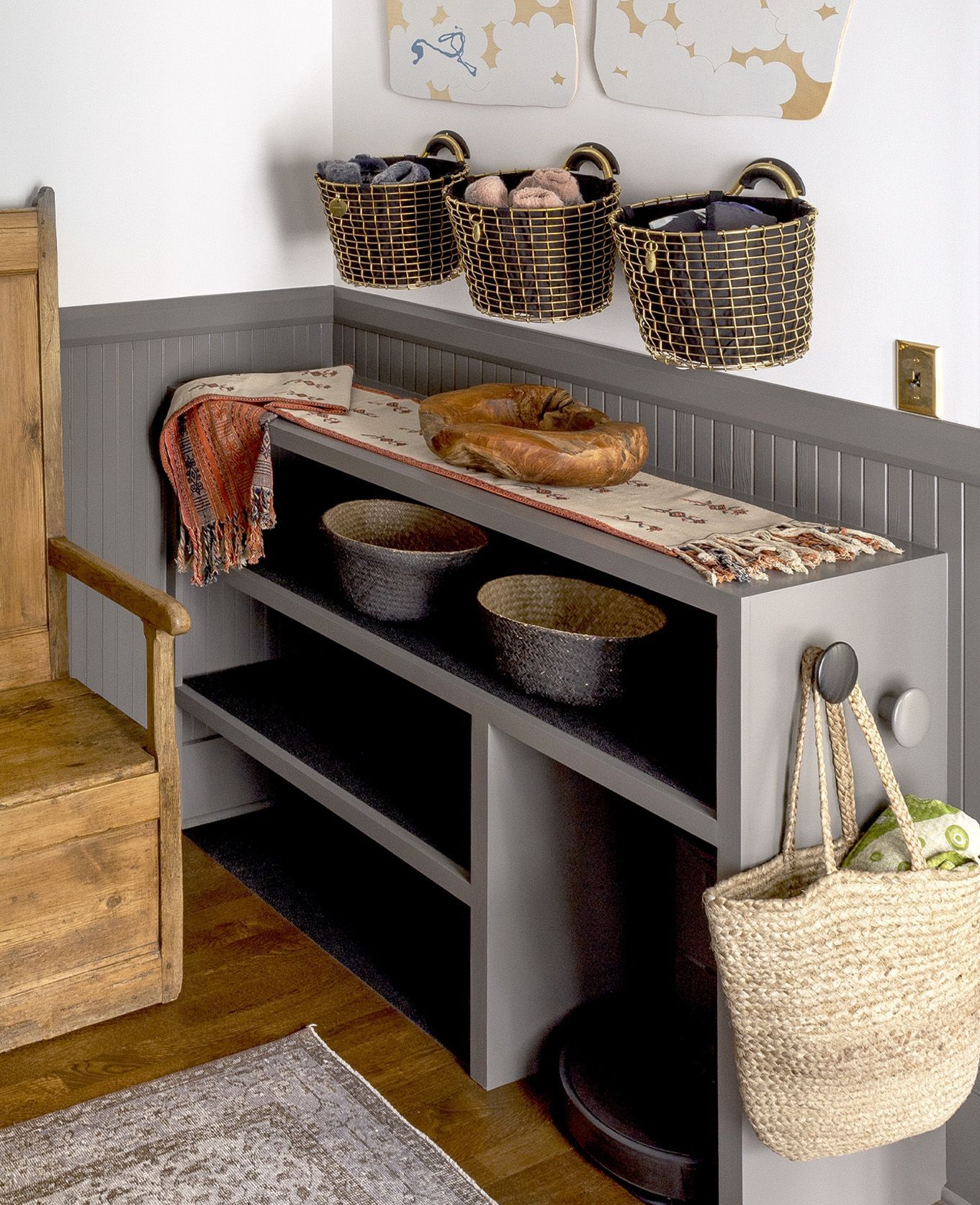 In the side entry/mudroom of this 1913 Colonial Revival home, a variety of basket shapes and sizes hold gear that is easily swapped out with the seasons.