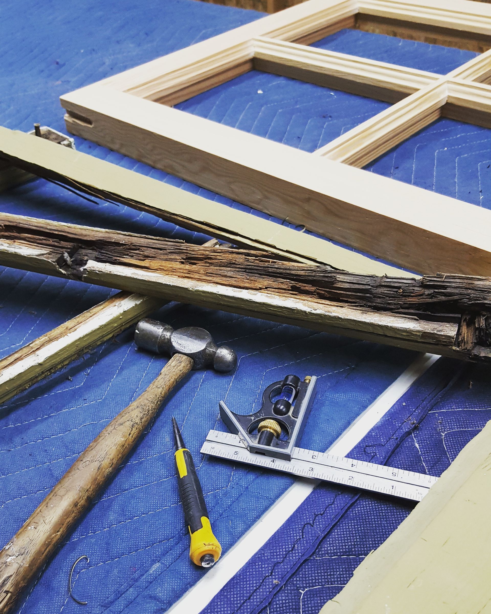 A hammer and a ruler are laying on a blue tarp