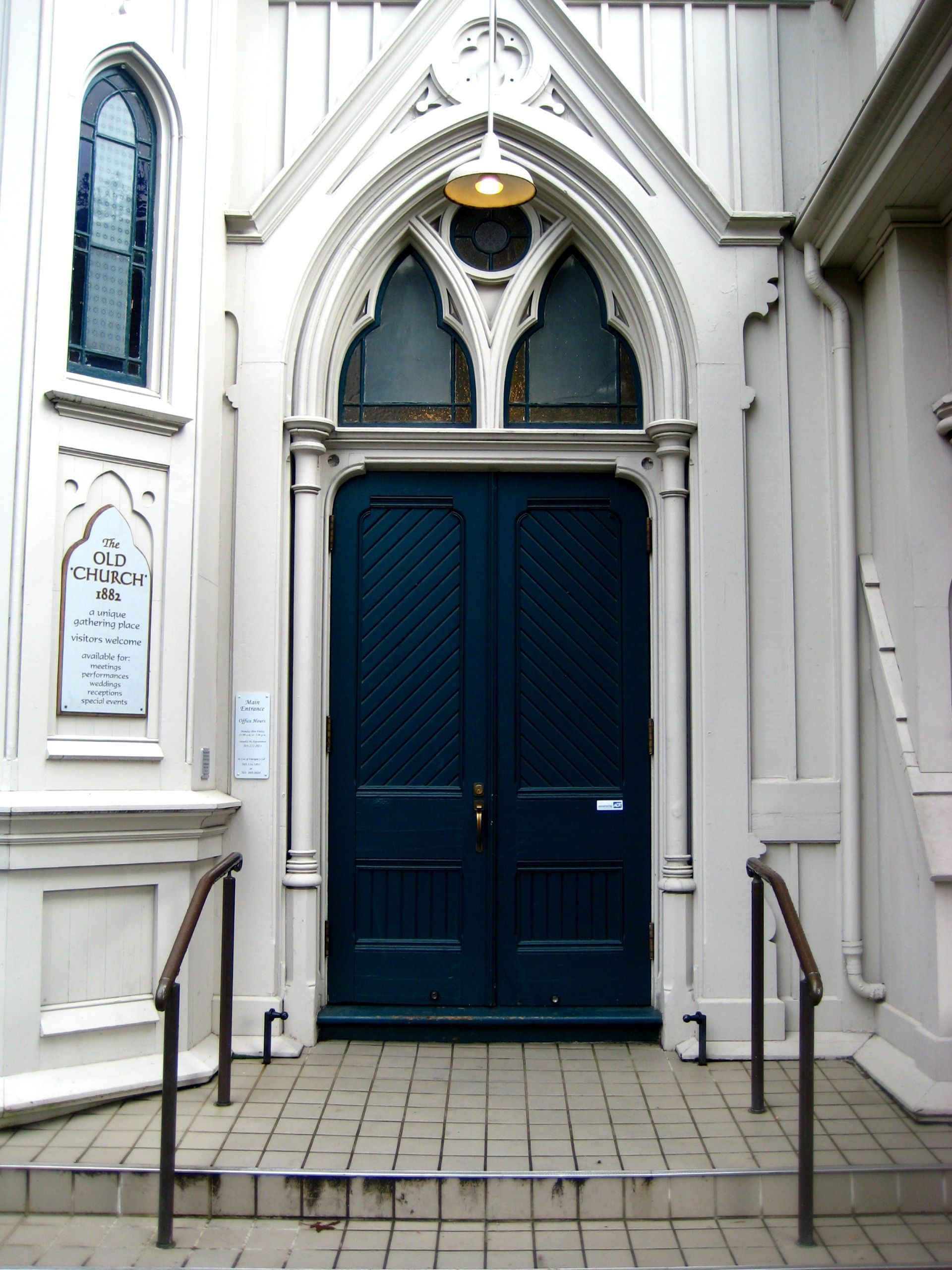 A church with a blue door and stairs leading up to it