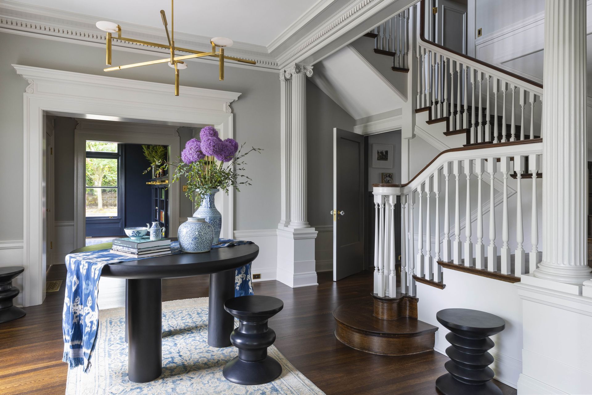 Classic grand entrance with a colonial staircase and contemporary fixtures and furnishings