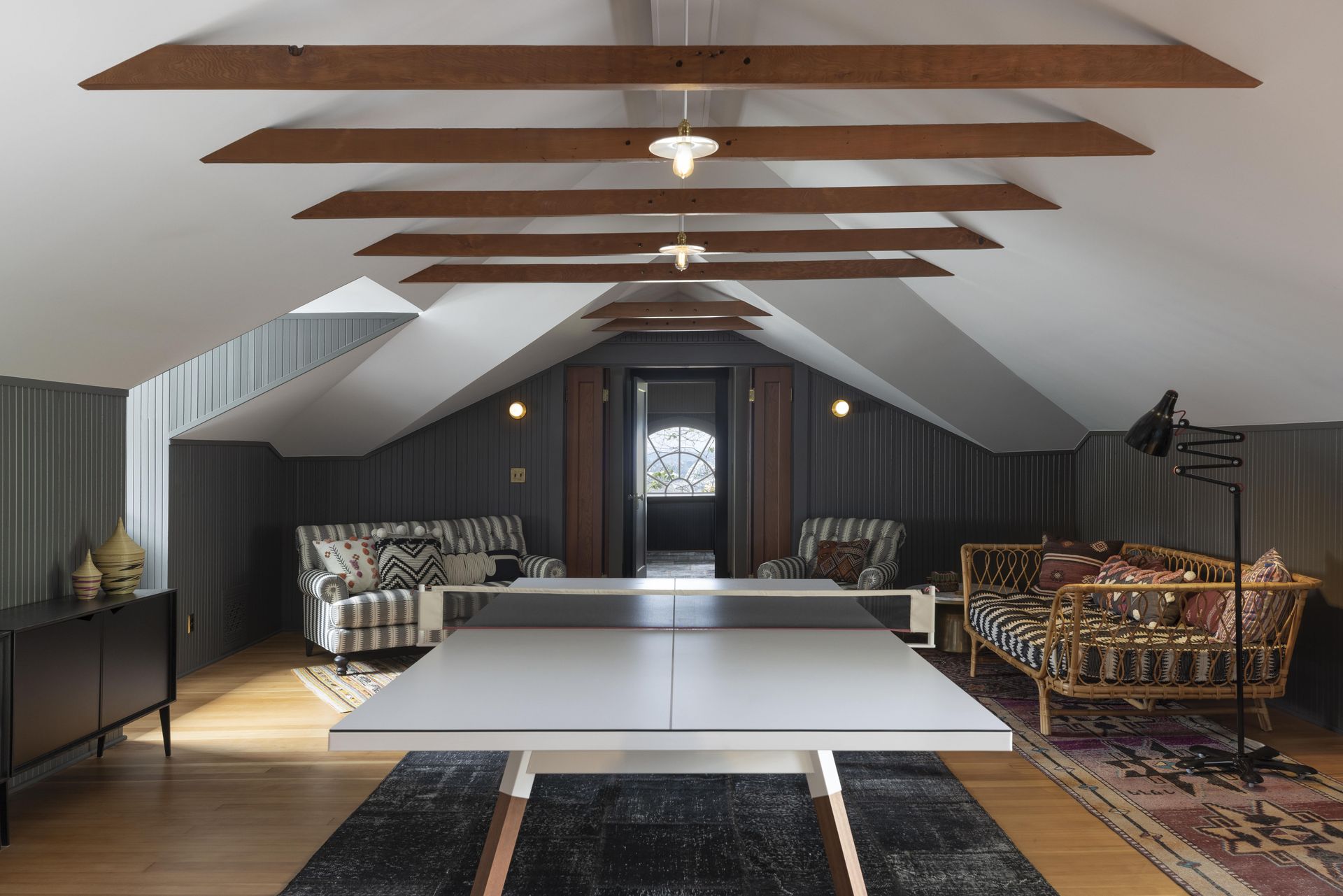 A kitchen with a sink , stove , and two windows.