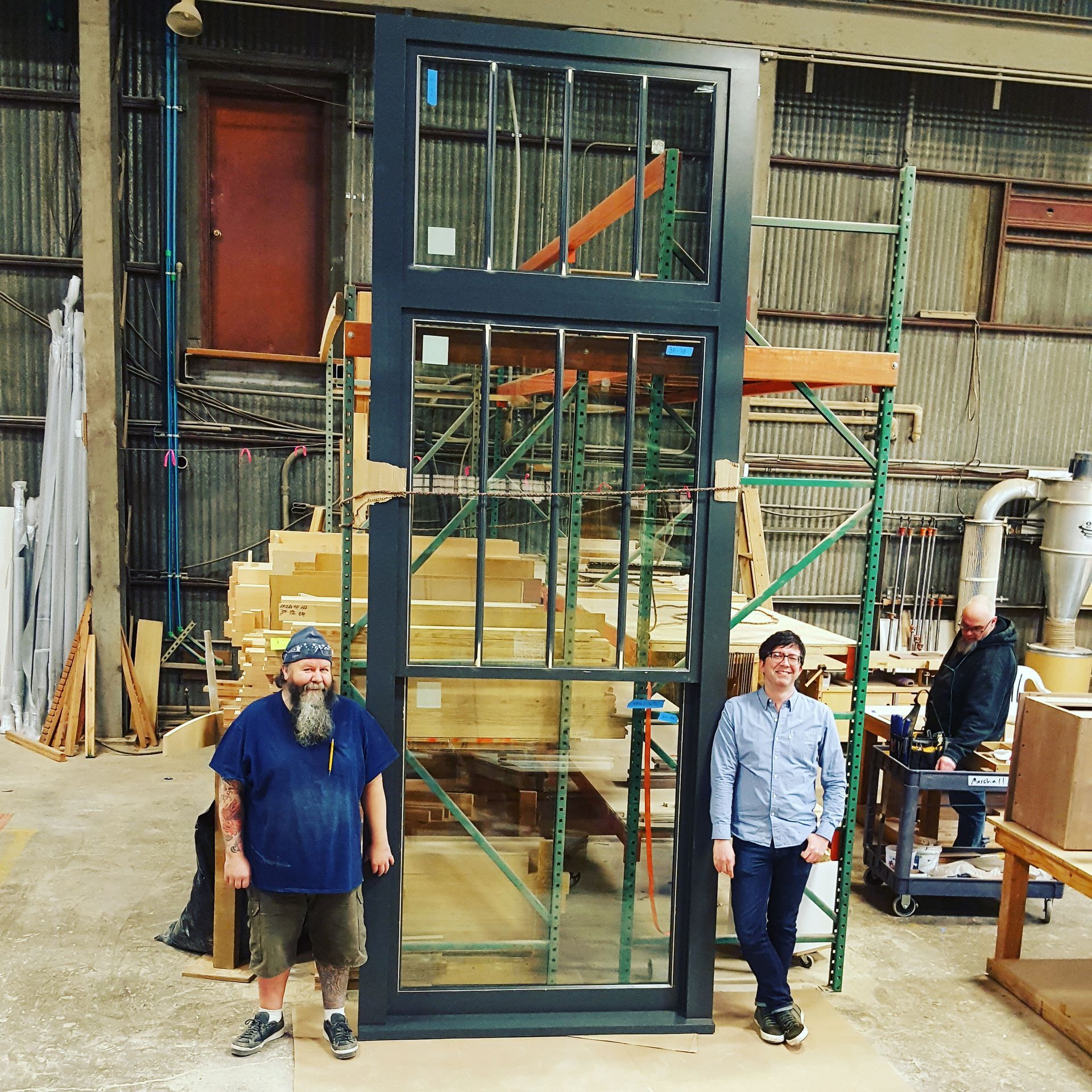Two men standing in front of a large glass door