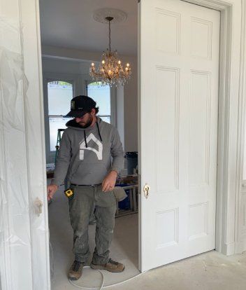Benjamin Houser shows off the pocket doors that are nearly 9 feet tall. Photo by Gingi Tilbury.
