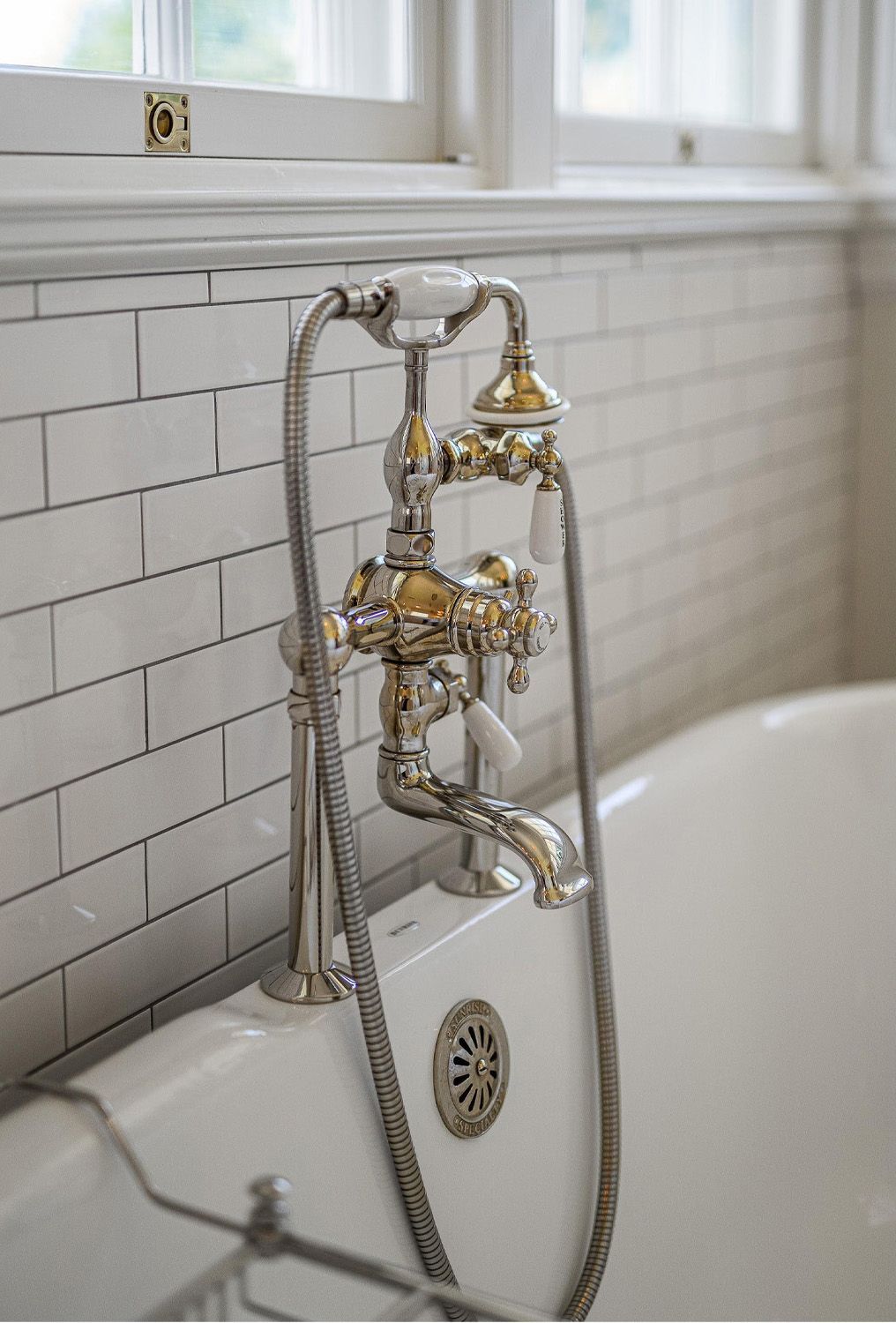 1916 Irvington Colonial Revival primary bedroom bathroom with vintage nickel tub faucet.