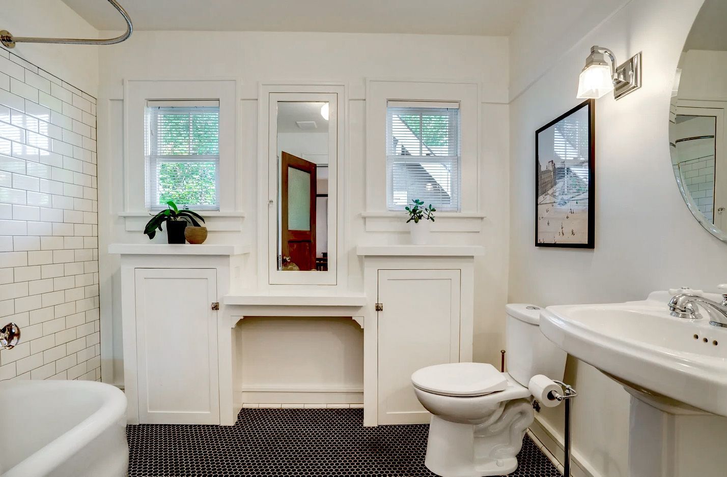 In another Irvington home, the original 1920bathroom features built-in storage cupboards with a vanity and medicine cabinet in between.