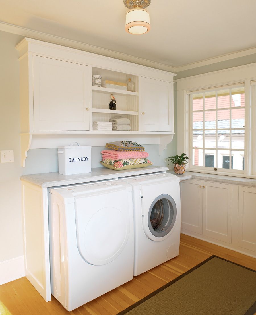 In the Sullivan's Gulch neighborhood of NE Portland, Arciform transformed the sleeping porch of a landmark Prairie Craftsman style home into a bright and charming laundry room. Built-in cabinets topped with a marble counter provide extra storage below the windows without blocking the views.