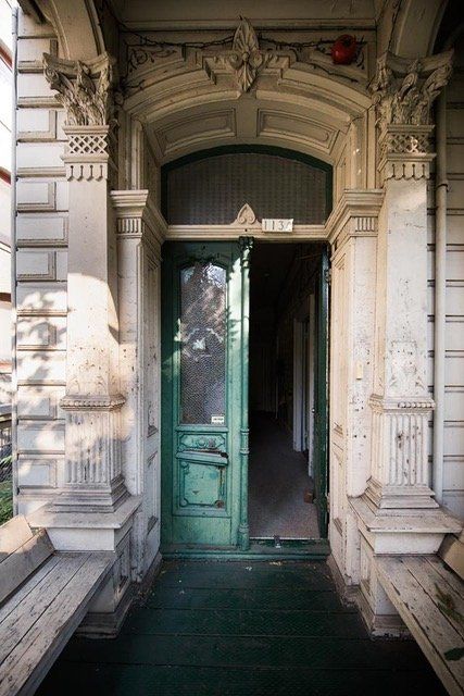 An old building with a green door that is open