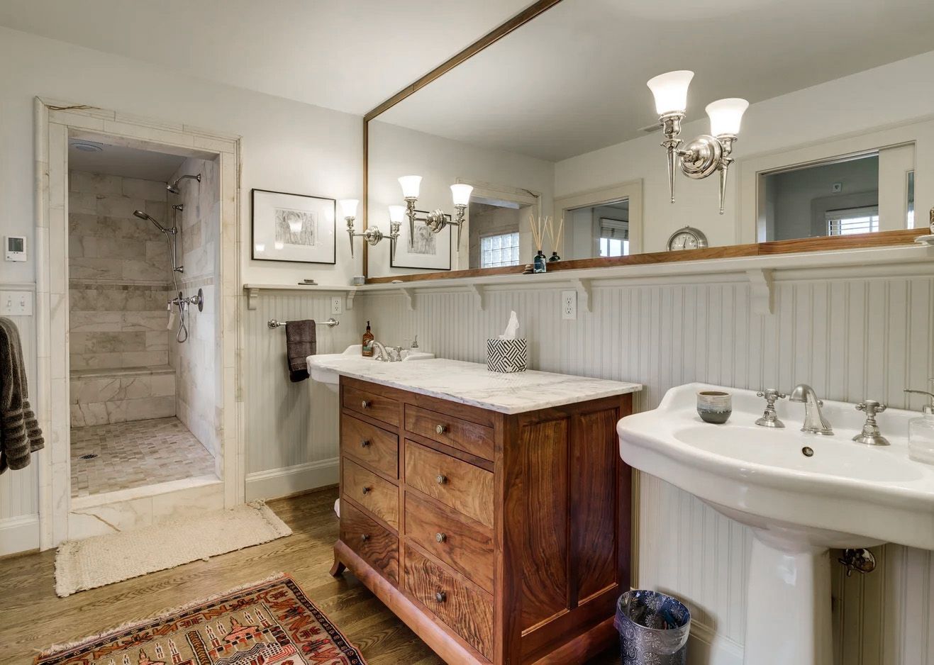 In this 1920s Irvington home, the remodeled bathroom features a custom storage dresser between the two sinks and a broad shelf for small items.