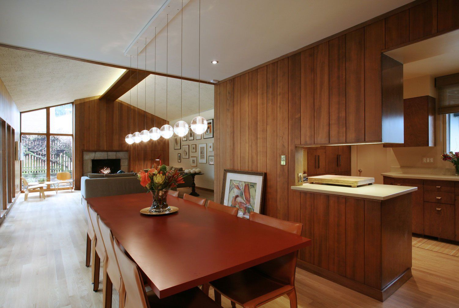 The custom red dining table under Bocci pendants, all in a row