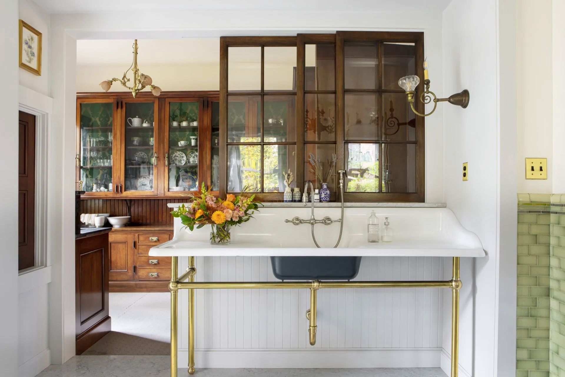 A kitchen with a sink and a vase of flowers on the counter