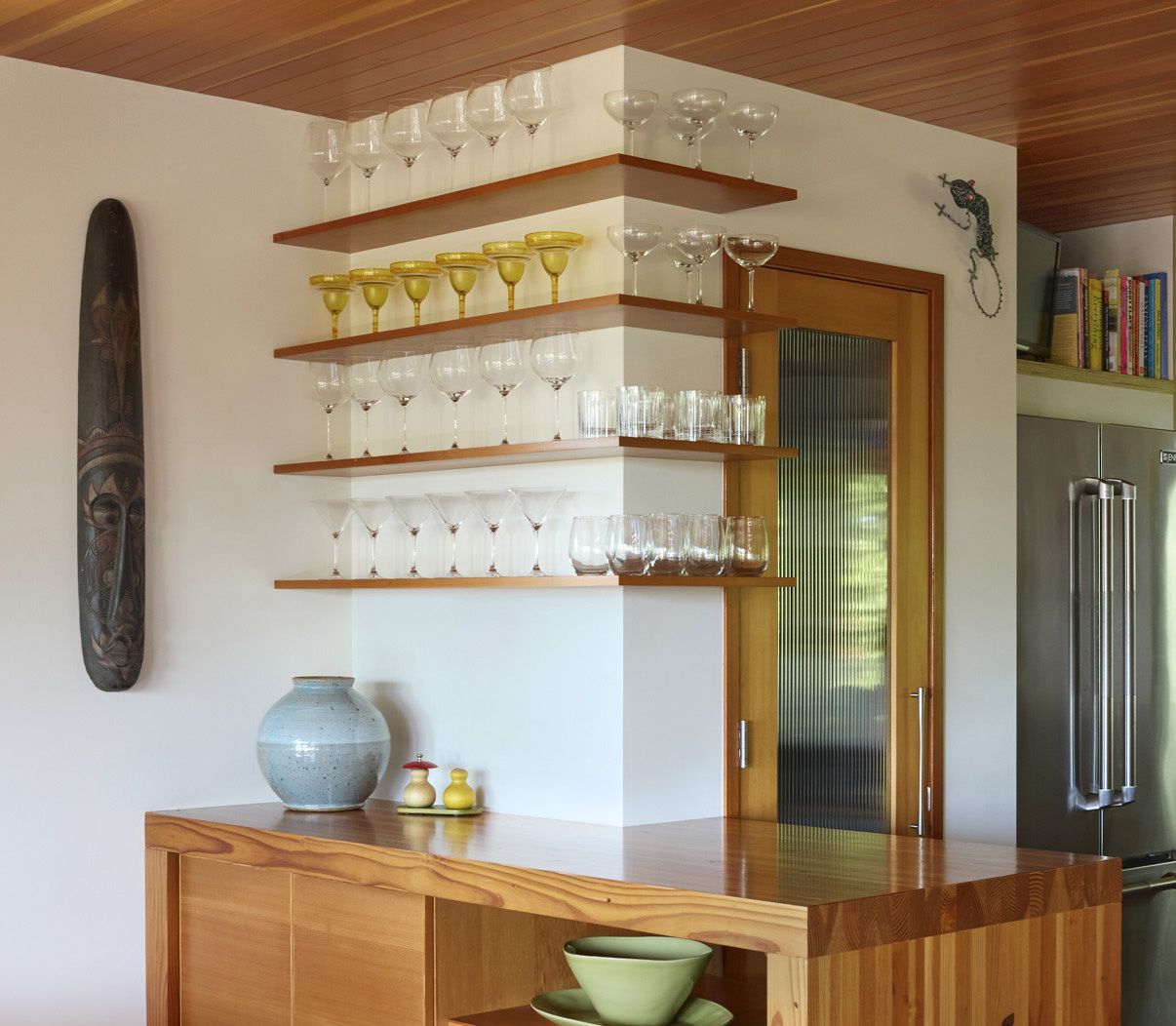 In the same 1950s home, floating Douglas fir shelves uniting the kitchen and dining room become an architectural feature on their own. 