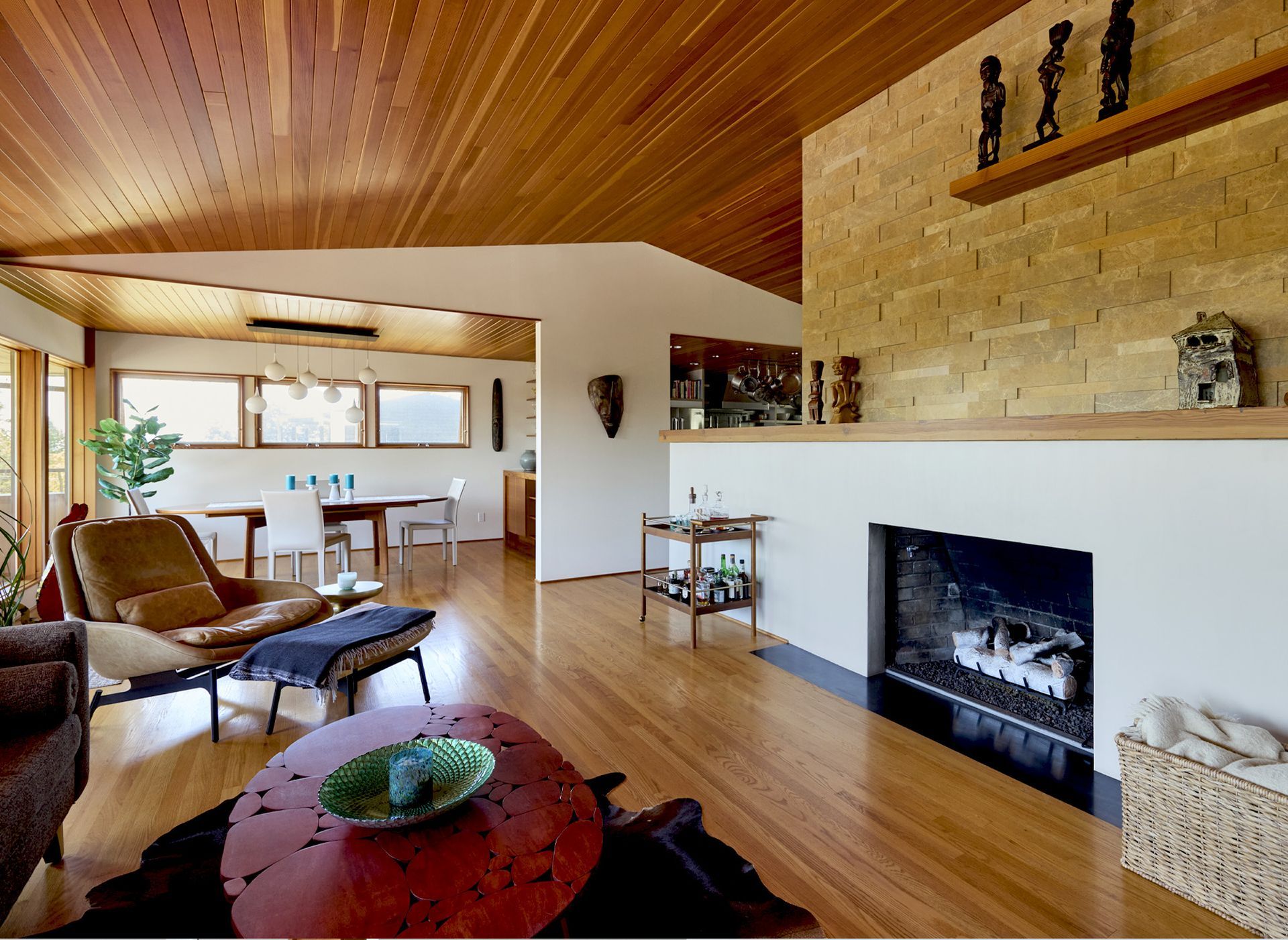 The fireplace is now sleek and scaled to the open living room, with a blackened steel hearth, white plastered surround and fir mantel meeting a stone clad chimney.