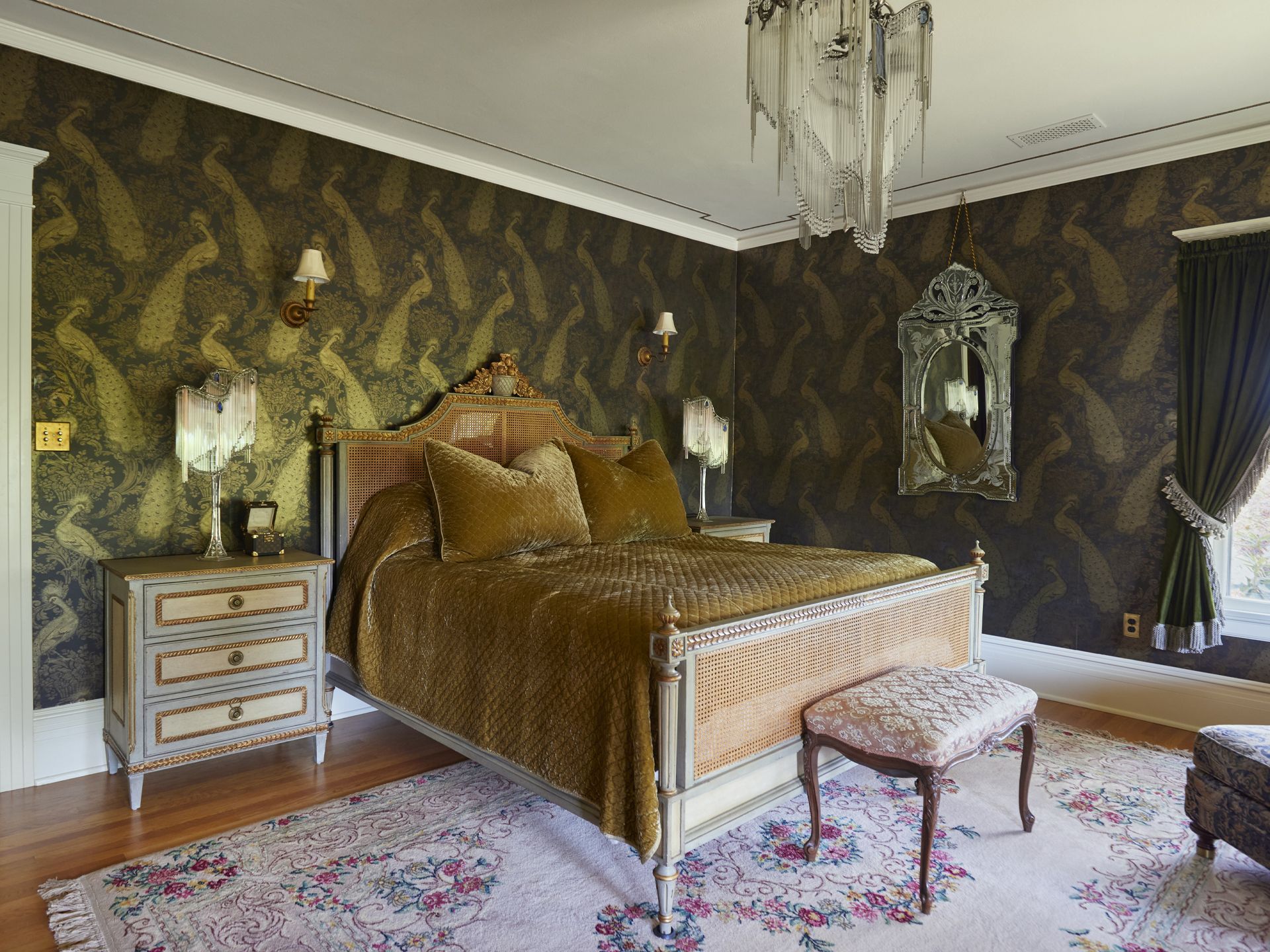 Adjacent to the shoe library, the main bedroom is glamorous with peacock wallpaper, velvet bedding and vintage French lighting.