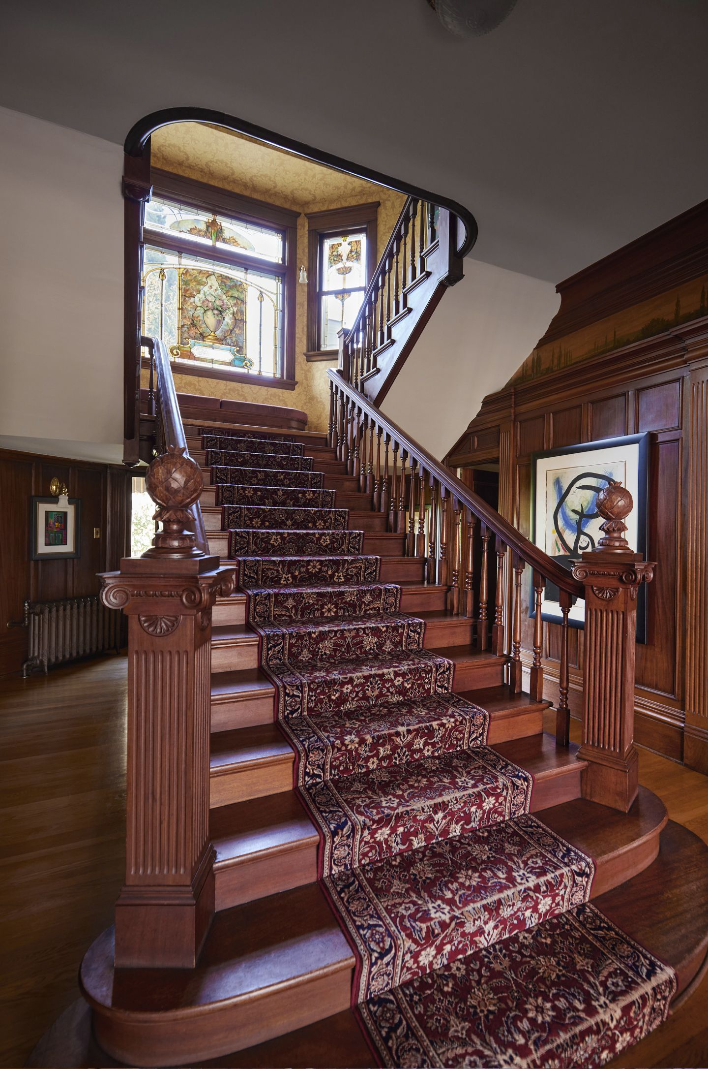 Looking up the main staircase from the entryway shows off the window at the first landing and all the original millwork.