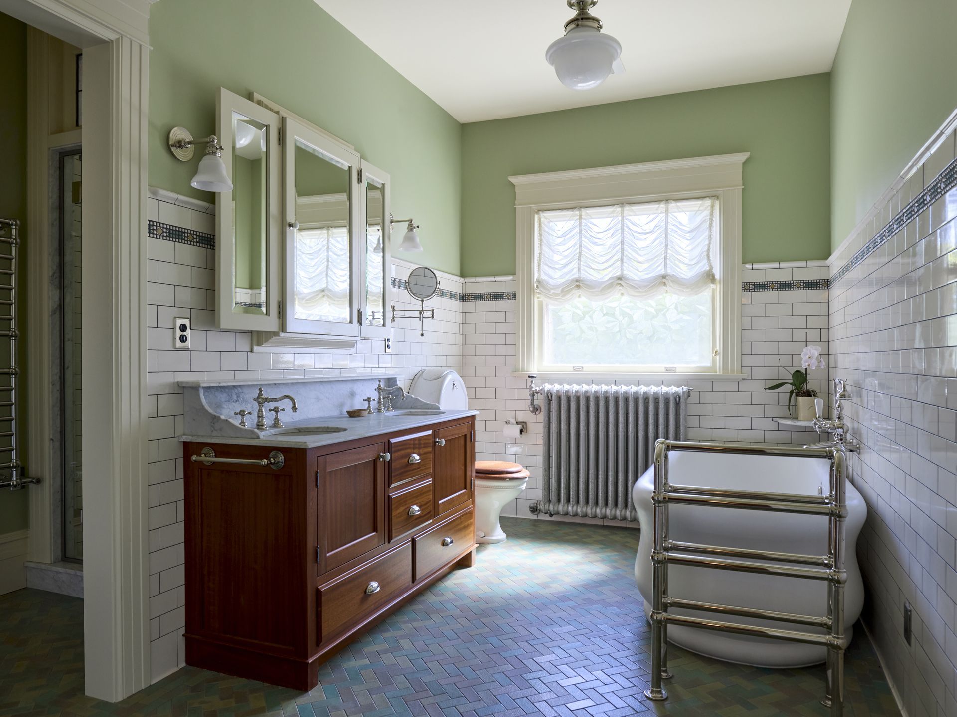 The main bathroom has updated plumbing systems with new finishes that closely match the old - from the marble topped vanity to the restored toilet and tile to mimic the original.