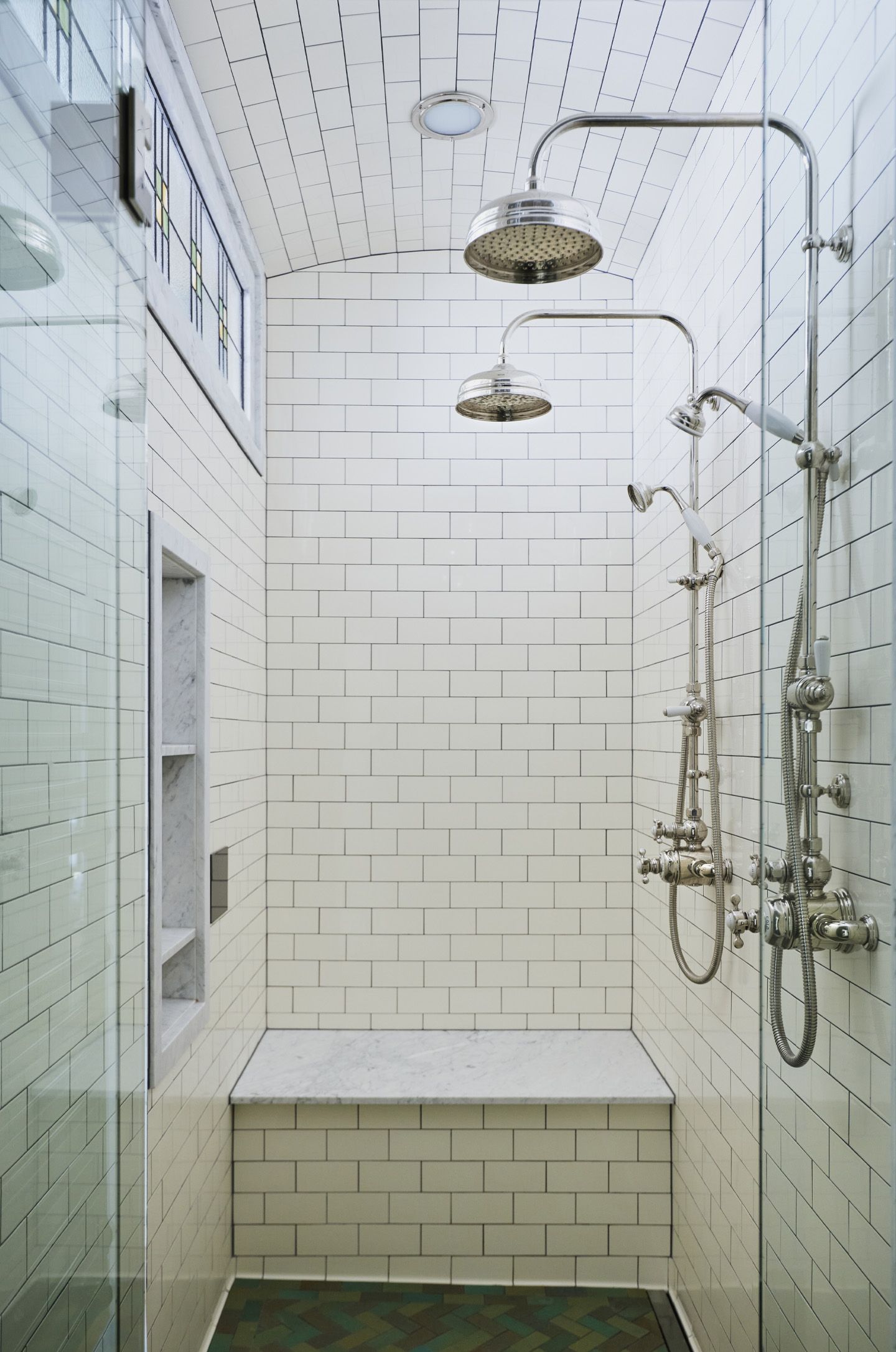 A steam shower for two with barrel-vaulted ceiling and a handy bench for shaving in back.