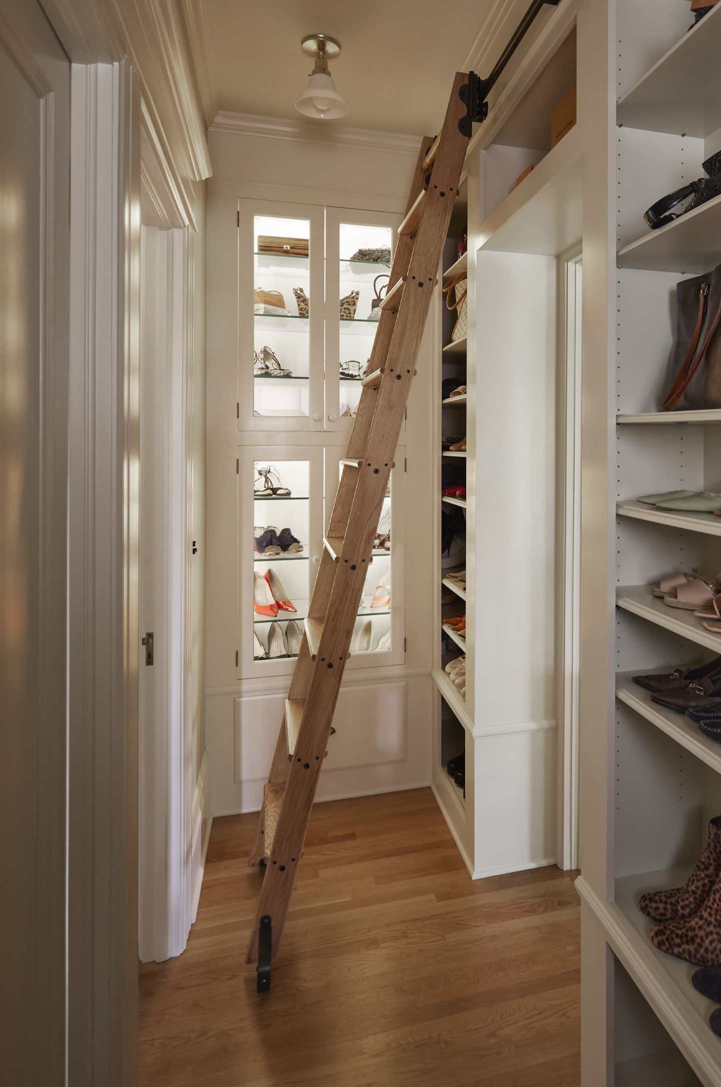 The length of the shoe library with shelves on the right and illuminated shoe cubbies in front of you.