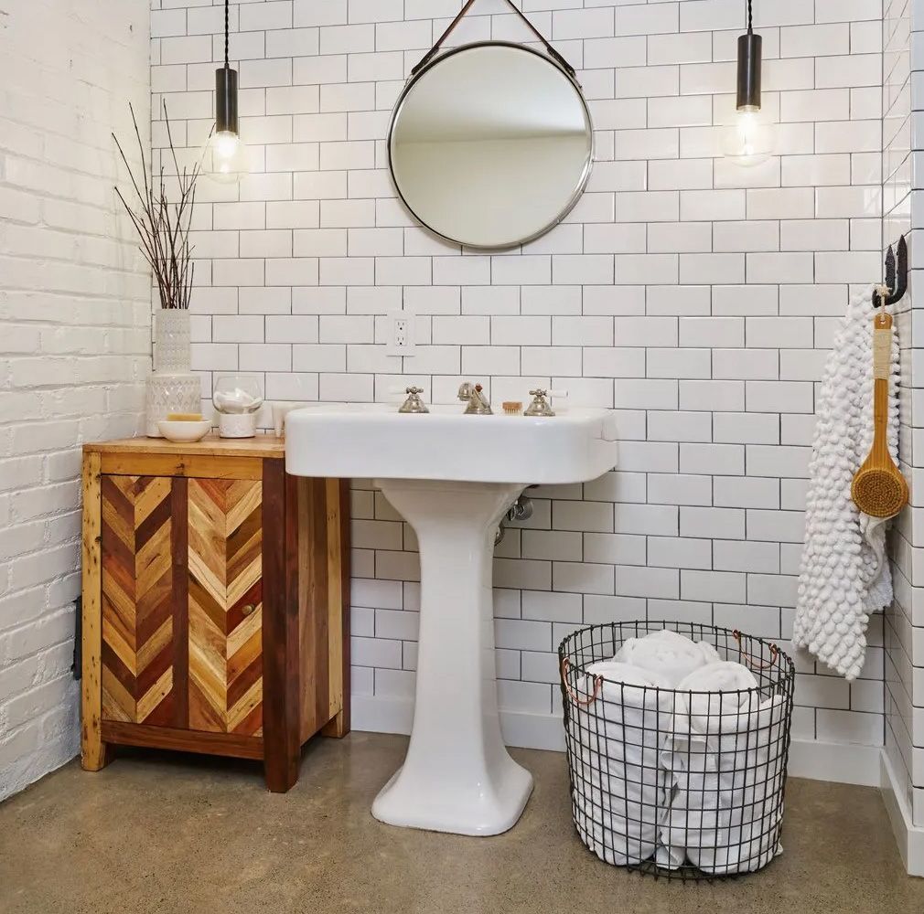 A new basement bathroom in a 1915 Portland Craftsman home carries on the theme of the original bathrooms with pedestal sink and subway tile walls.