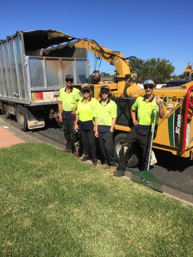 A Group of People Are Standing in Front of a Truck — Jeff Pearce Tree Services in Tuncurry, NSW
