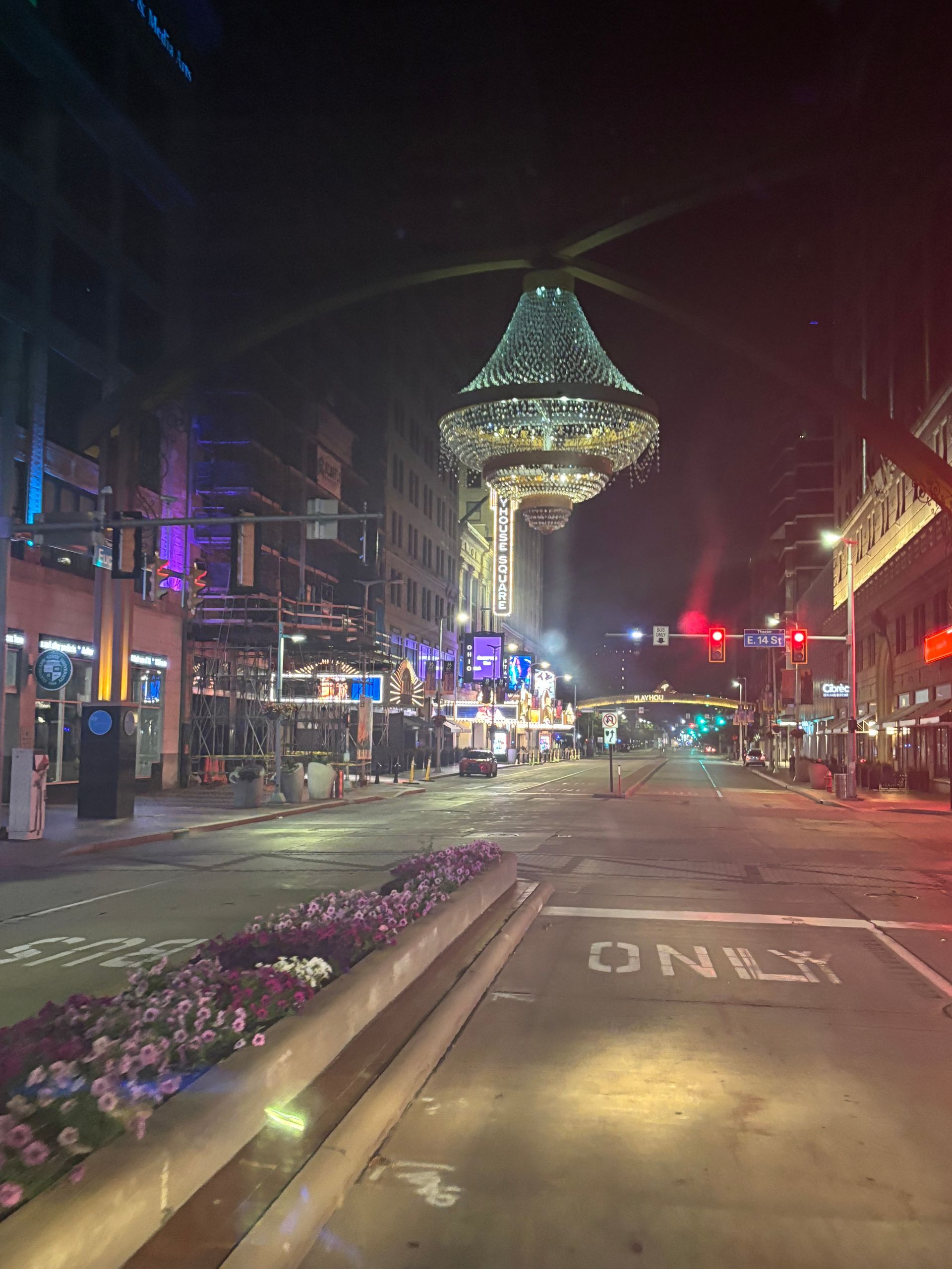 An empty city street at night with a helicopter in the background