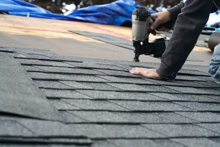 A man is working on the roof of a house.