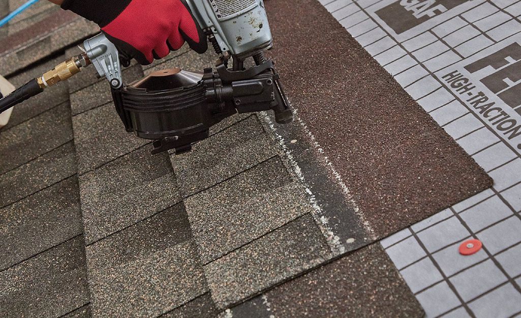 A man is working on the roof of a house.