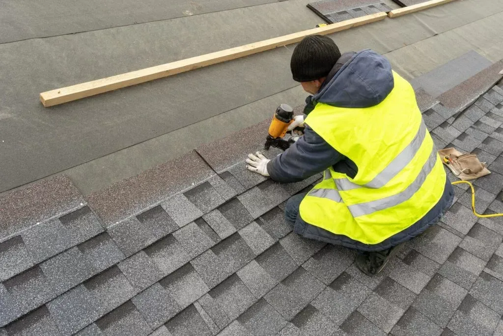 A skilled professional master meticulously covers the roof, ensuring precise craftsmanship and durable protection for the structure beneath.