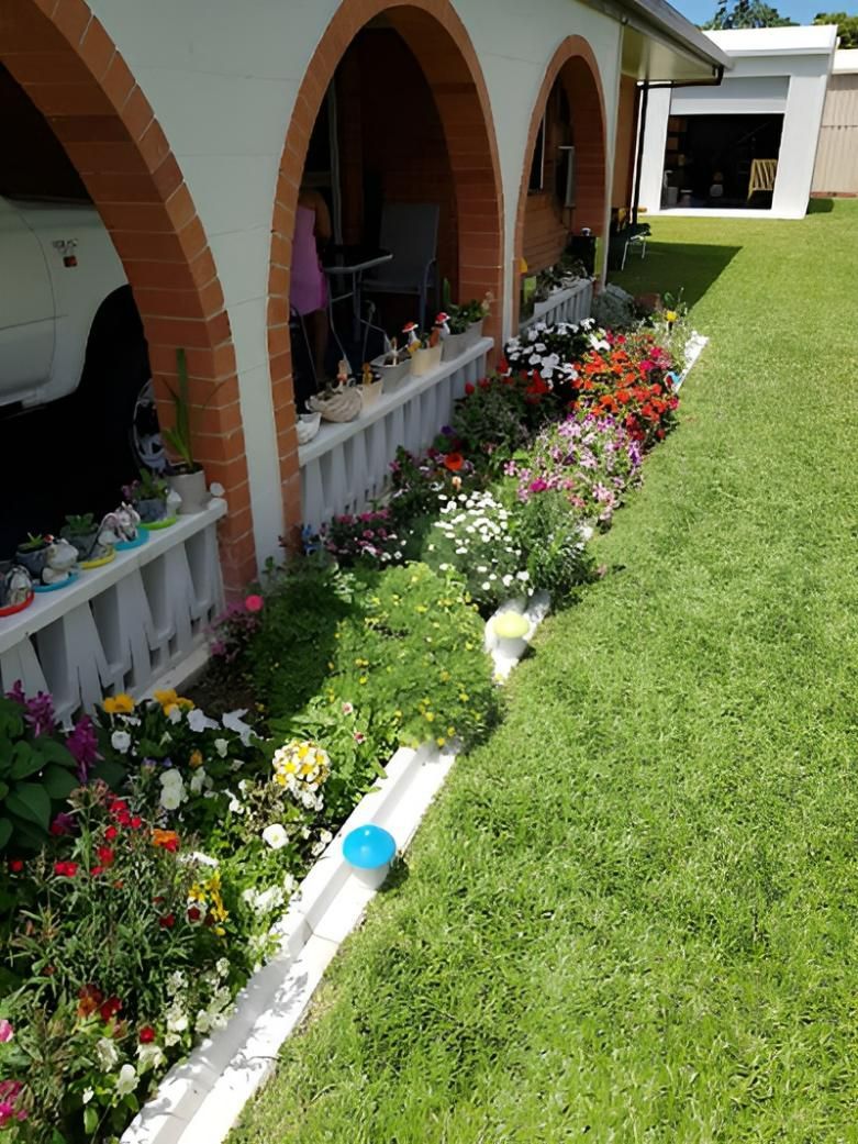 House With A Lot of Flowers In Front Of It — Eclipse Lawn Maintenance in Edmonton, QLD