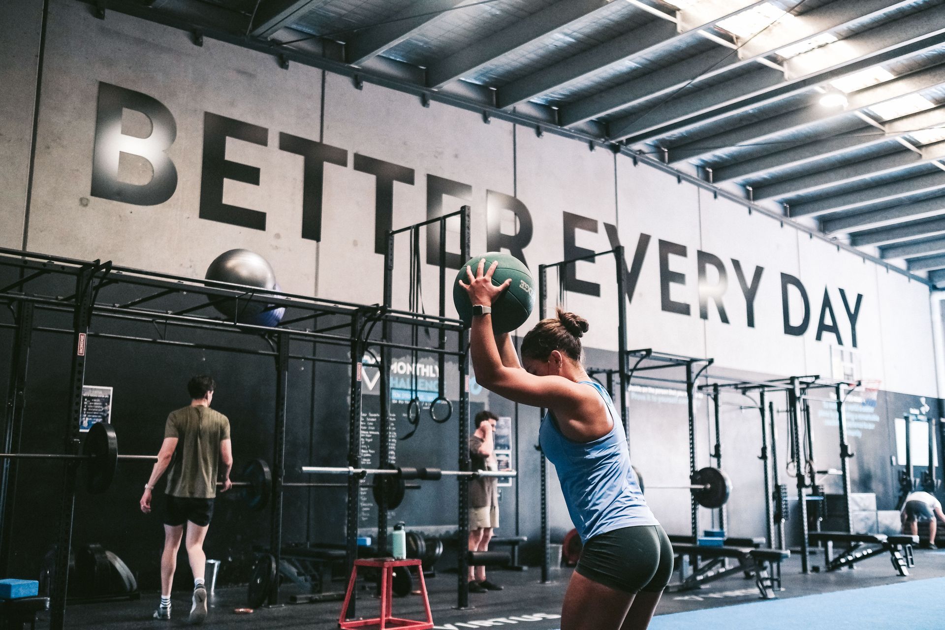 Woman throwing medicine ball in gym;