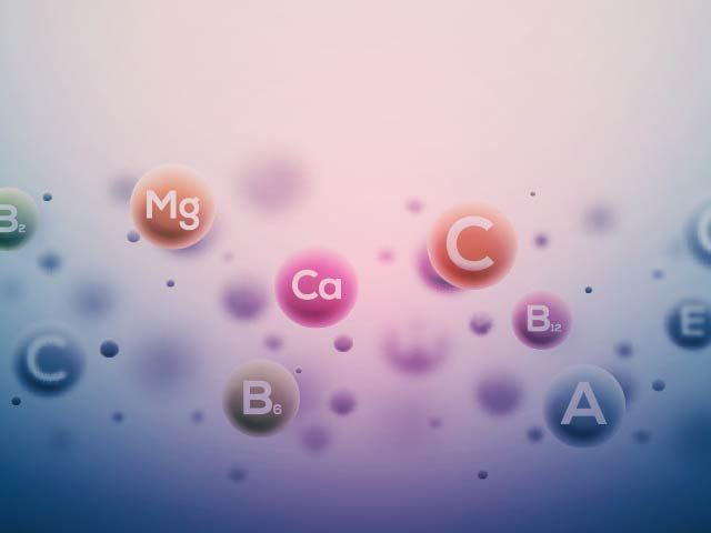 A bunch of vitamins are floating in the air on a purple background.
