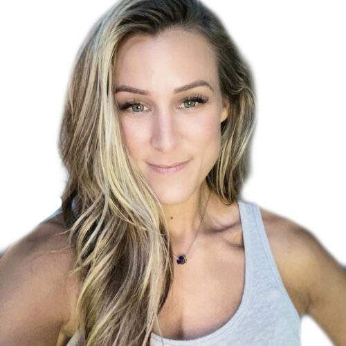 Woman with blonde hair smiles, wearing a gray tank top and necklace, outdoors.