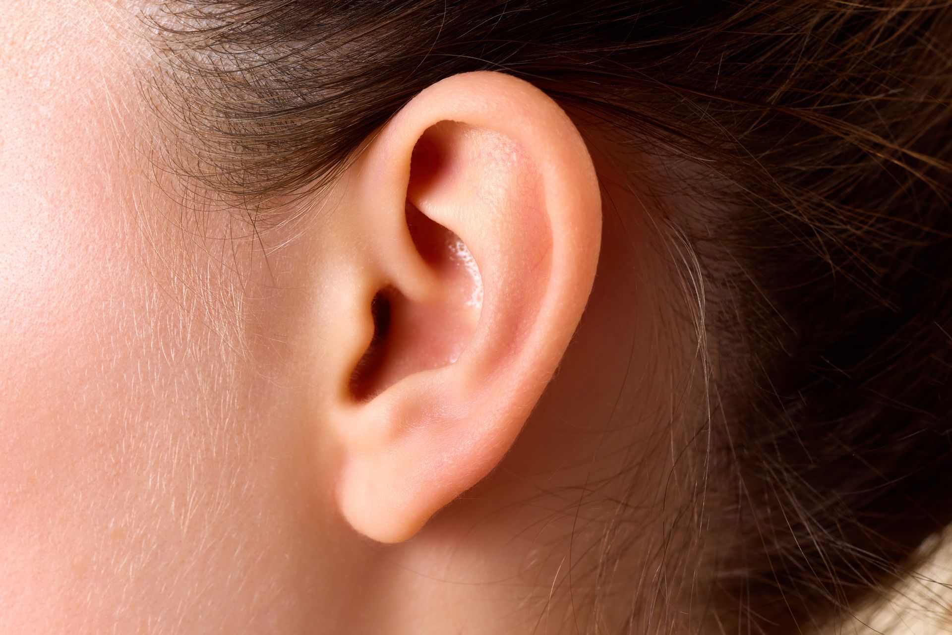 A close up of a woman 's ear with a bun.