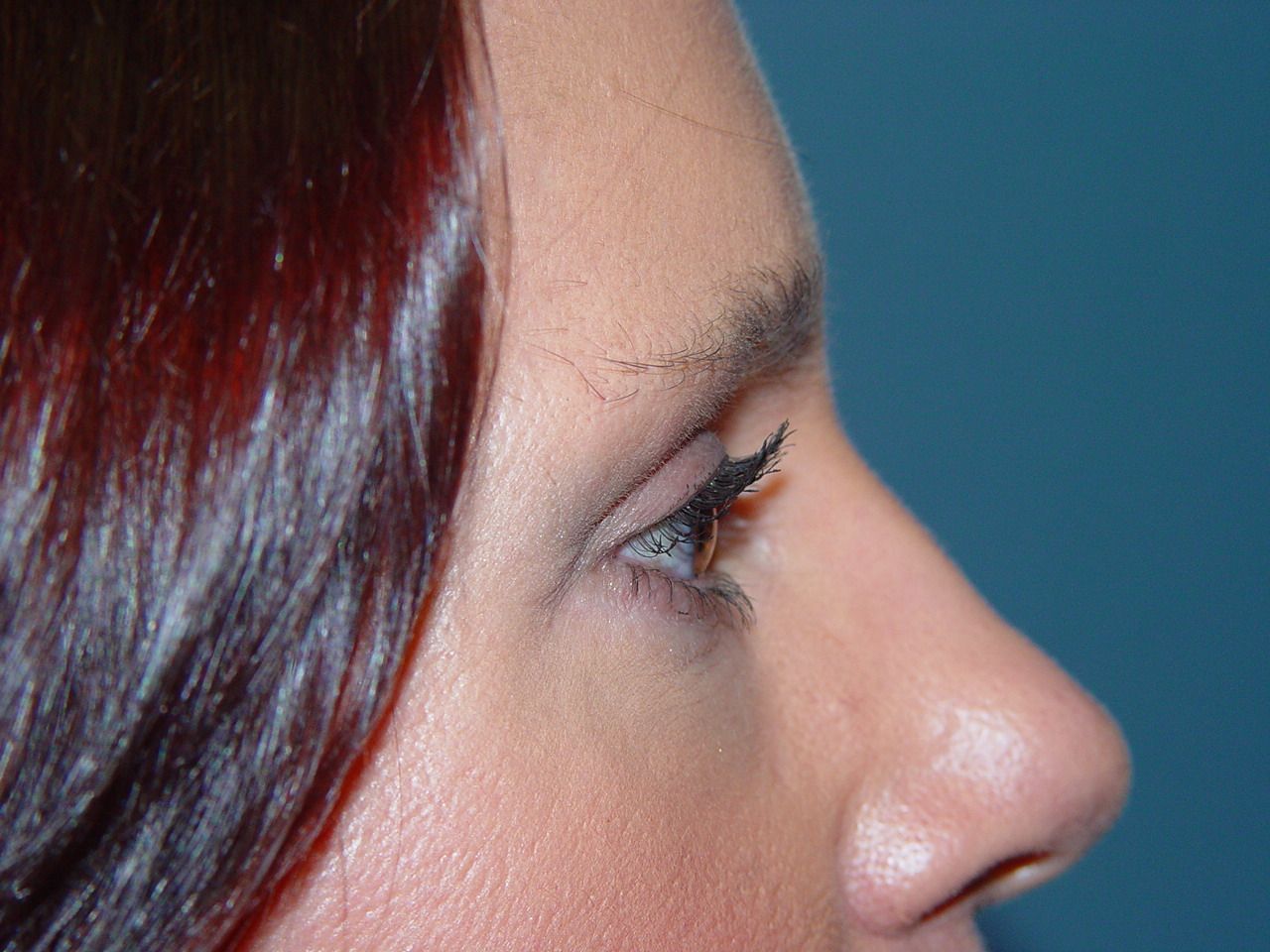 A close up of a woman 's face with a blue background.