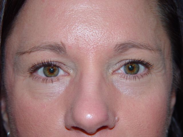 A close up of a woman 's face with her eyes closed.