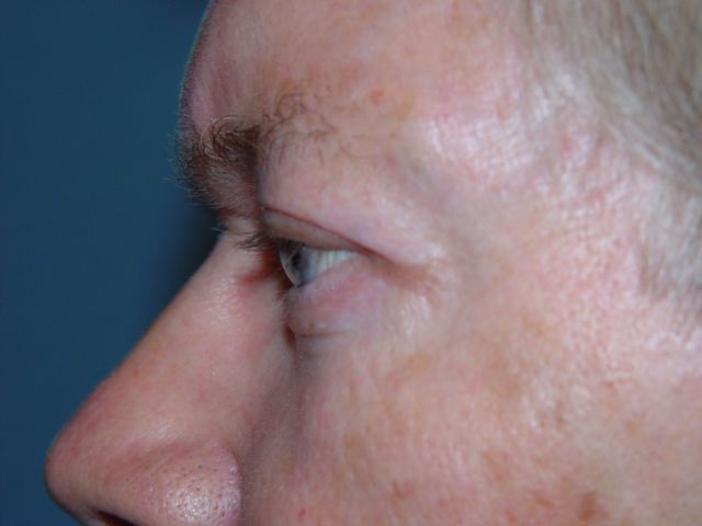 A close up of a woman 's face with a blue background.