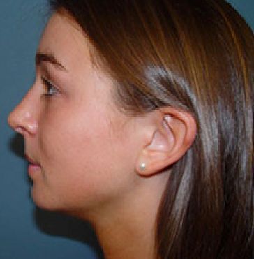 A close up of a woman 's face with earrings in her ears.