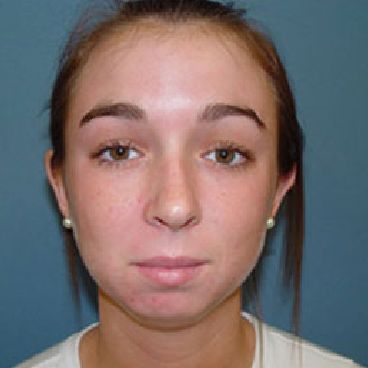 A close up of a woman 's face with a blue background.