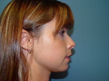 A close up of a woman 's face with long hair and earrings.