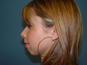 A close up of a woman 's face with hoop earrings.