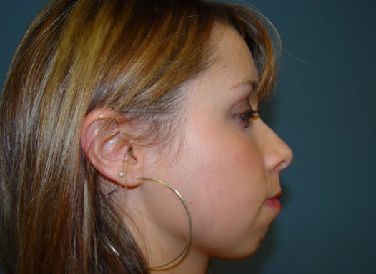 A close up of a woman 's face with hoop earrings.