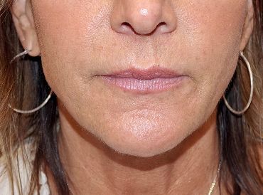 A close up of a woman 's face with hoop earrings.